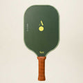 Green pickleball paddle with brown handle on a beige background